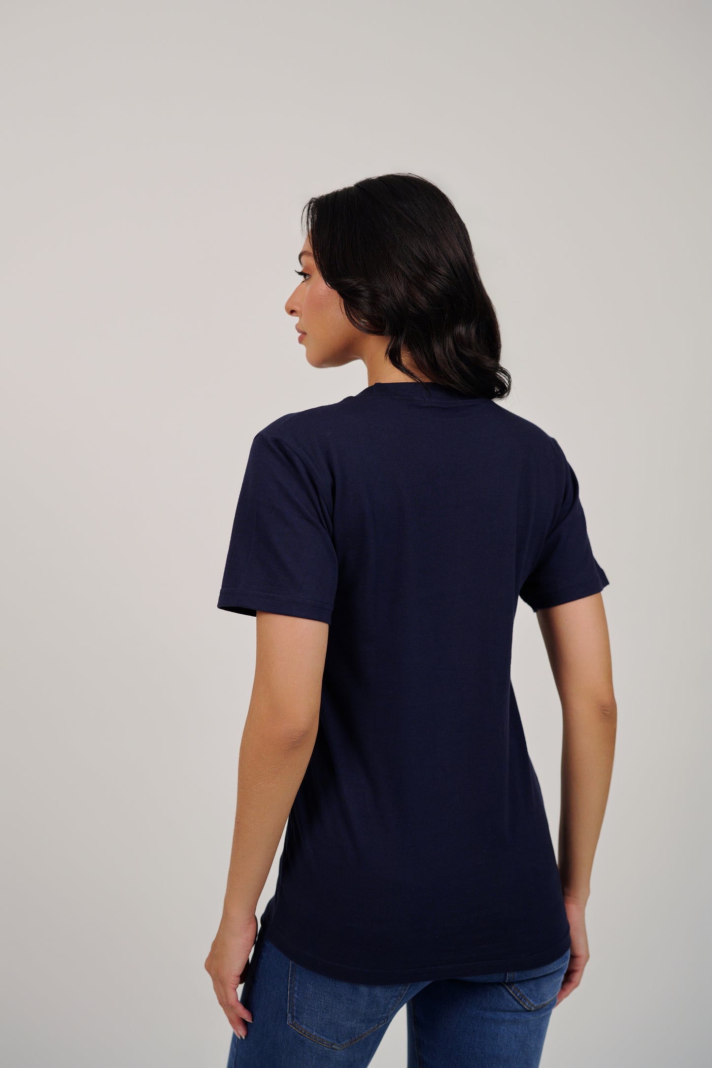 Woman wearing a navy blue t-shirt on a plain background
