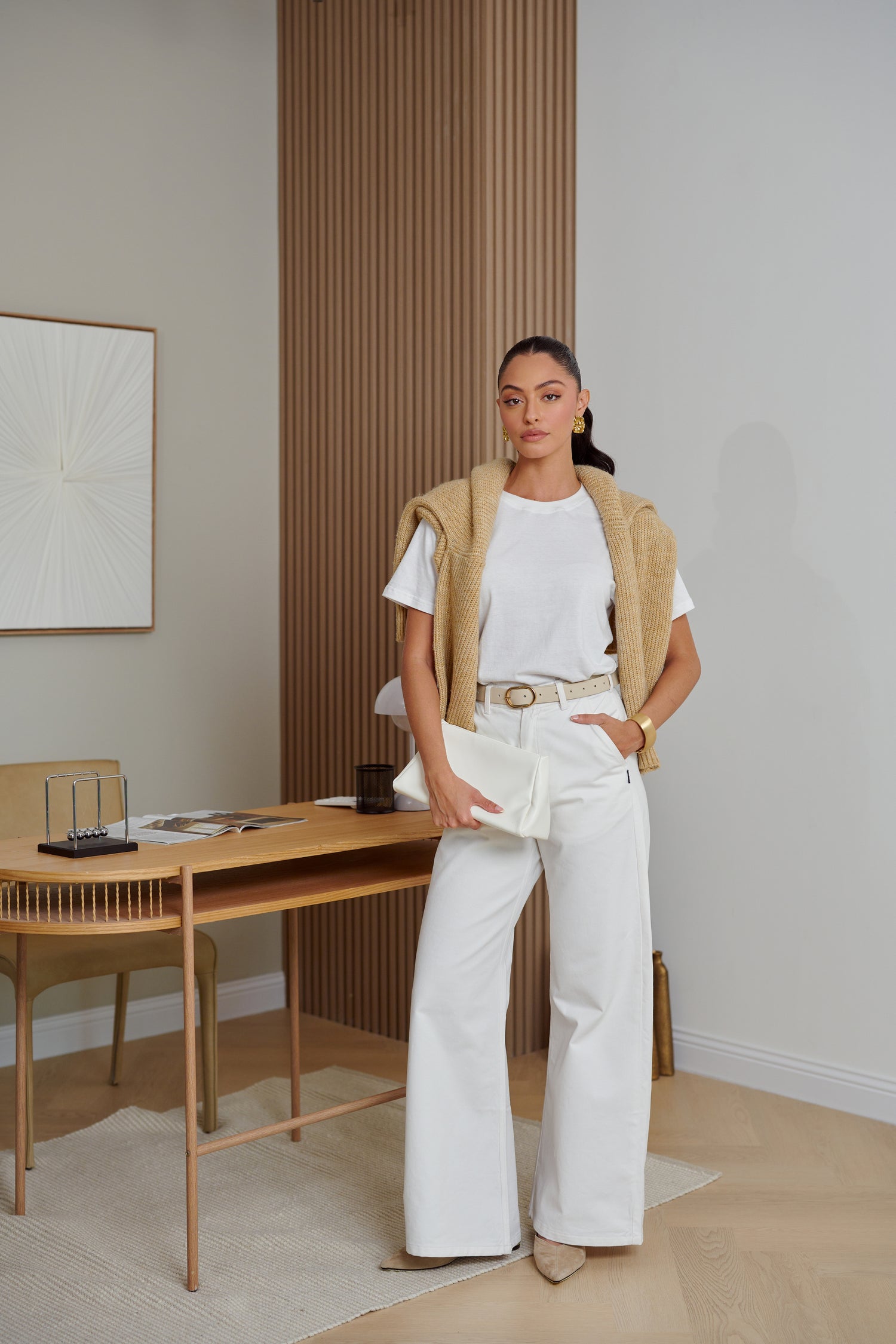 Woman standing in a modern room with a desk and minimal decor