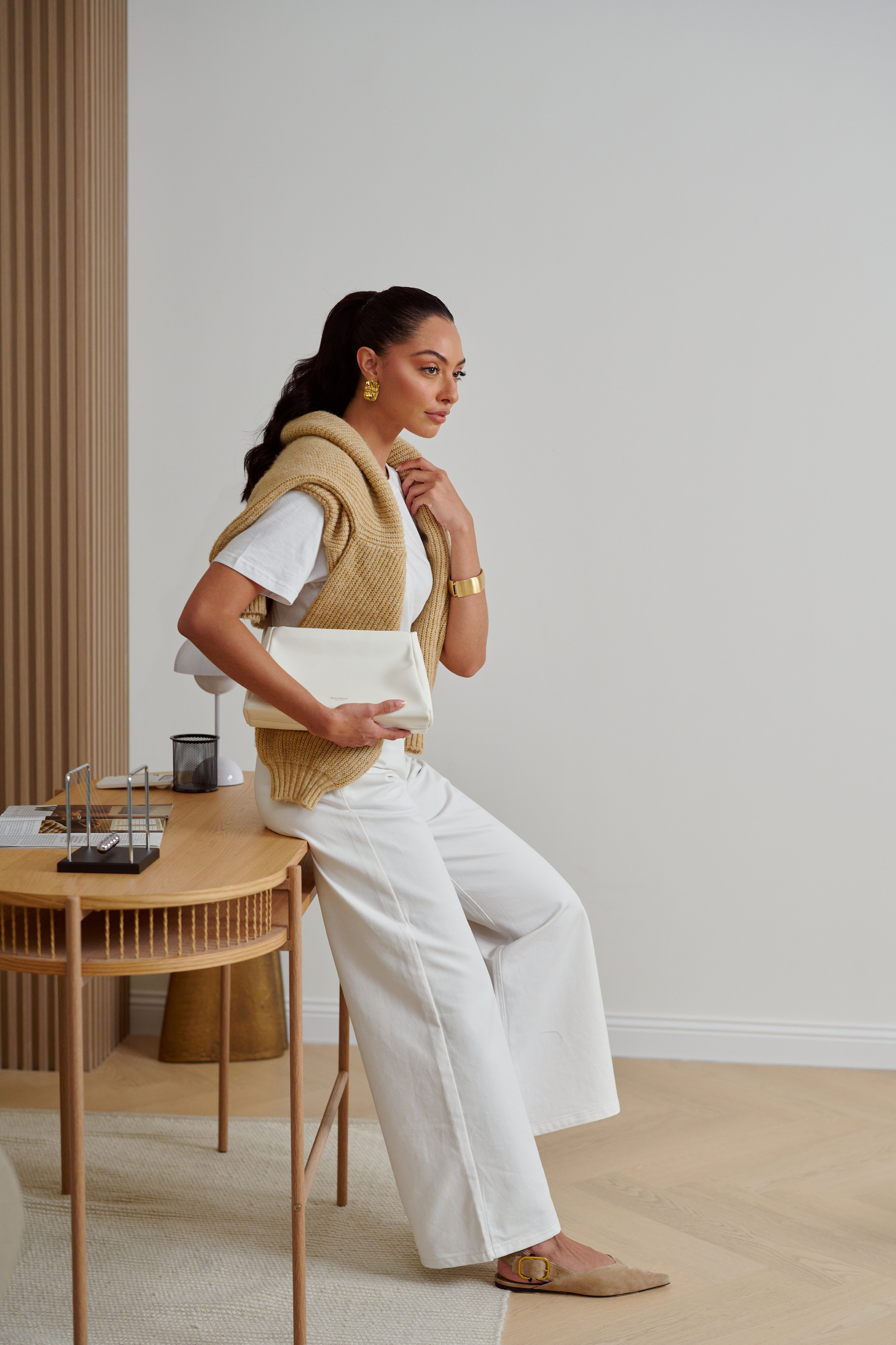 Woman sitting at a wooden desk in a minimalistic room