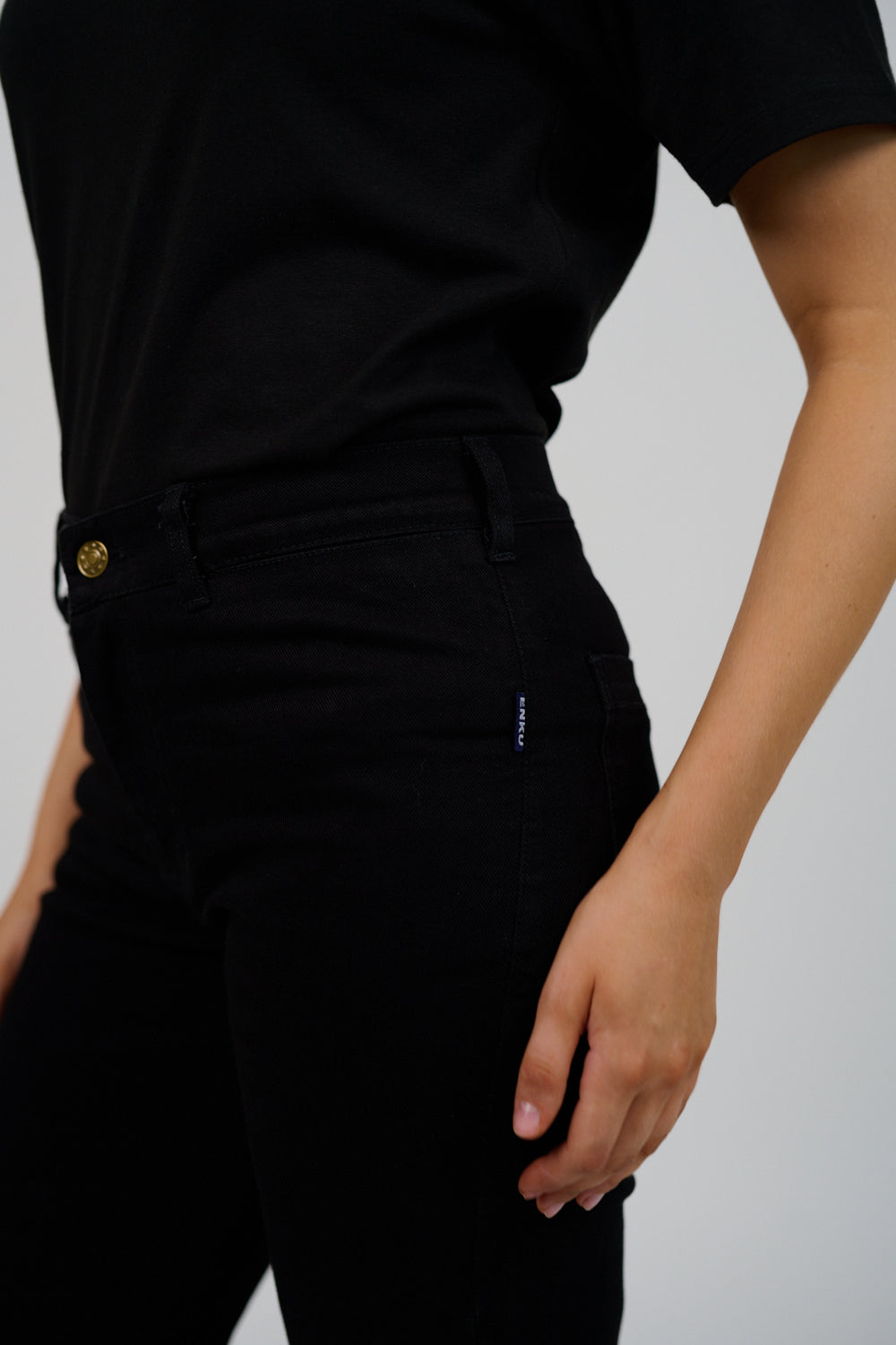 Person wearing a black outfit with a plain background