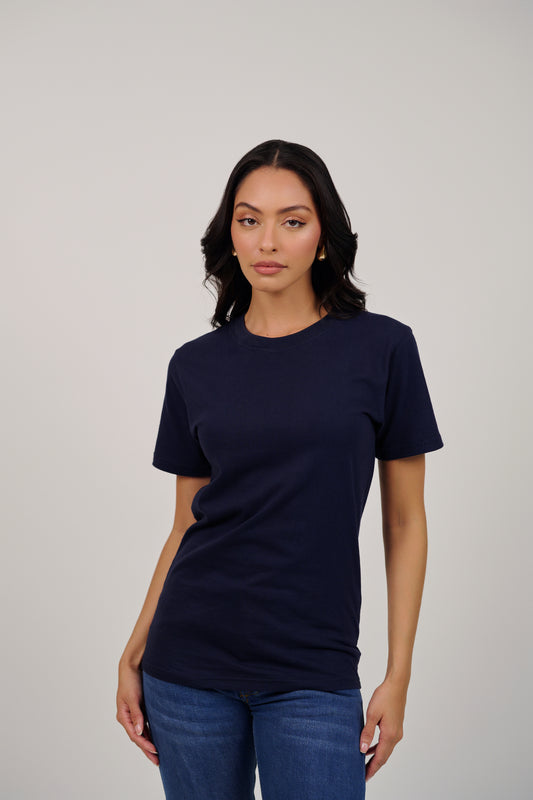 Woman wearing a navy blue t-shirt and jeans against a plain background
