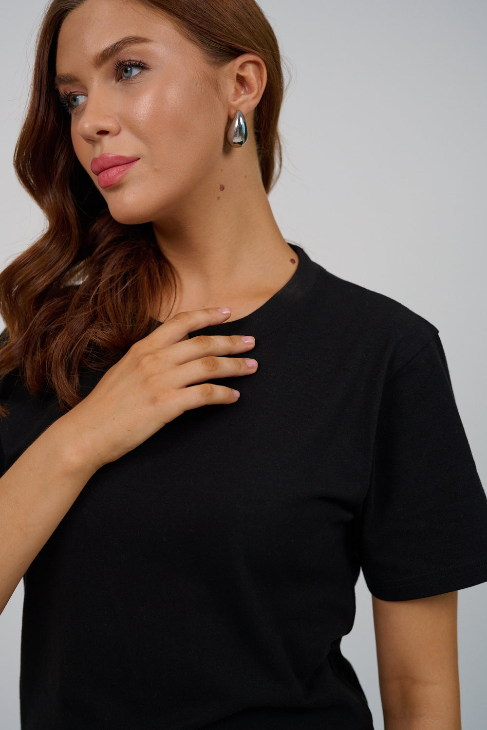 Woman wearing a black t-shirt against a plain background